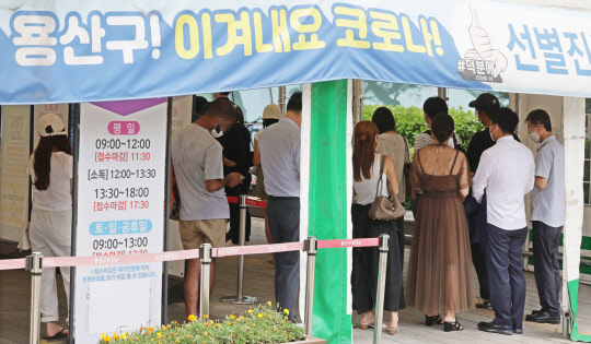 코로나19 유행이 증가세로 돌아선 가운데 6일 2만명에 육박하는 신규 확진자가 발생했다. 6일 서울 용산구보건소 선별진료소에서 시민들이 검사를 받기 위해 줄을 서 있다.  연합뉴스